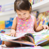 BIPOC female child reading children's book